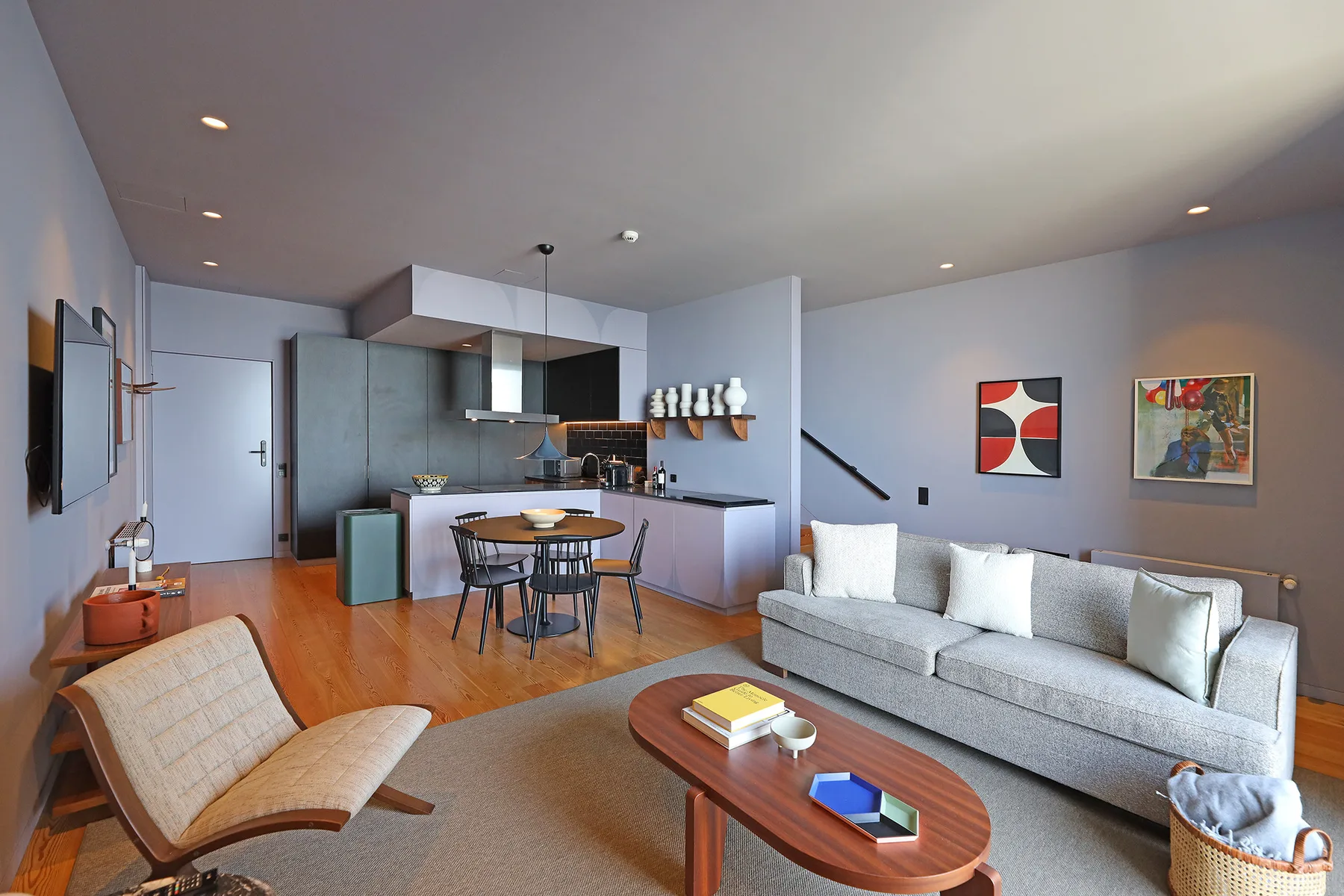 An open-plan living room and kitchen with a dining table and seating.