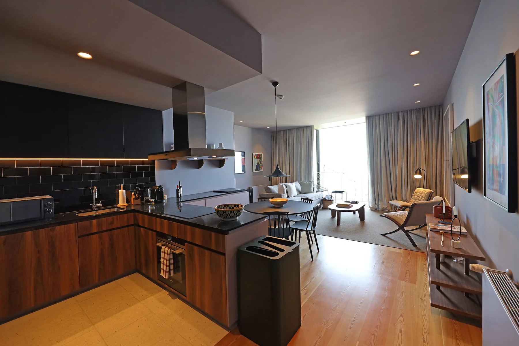 An open-plan kitchen and living area with a dining table and seating.