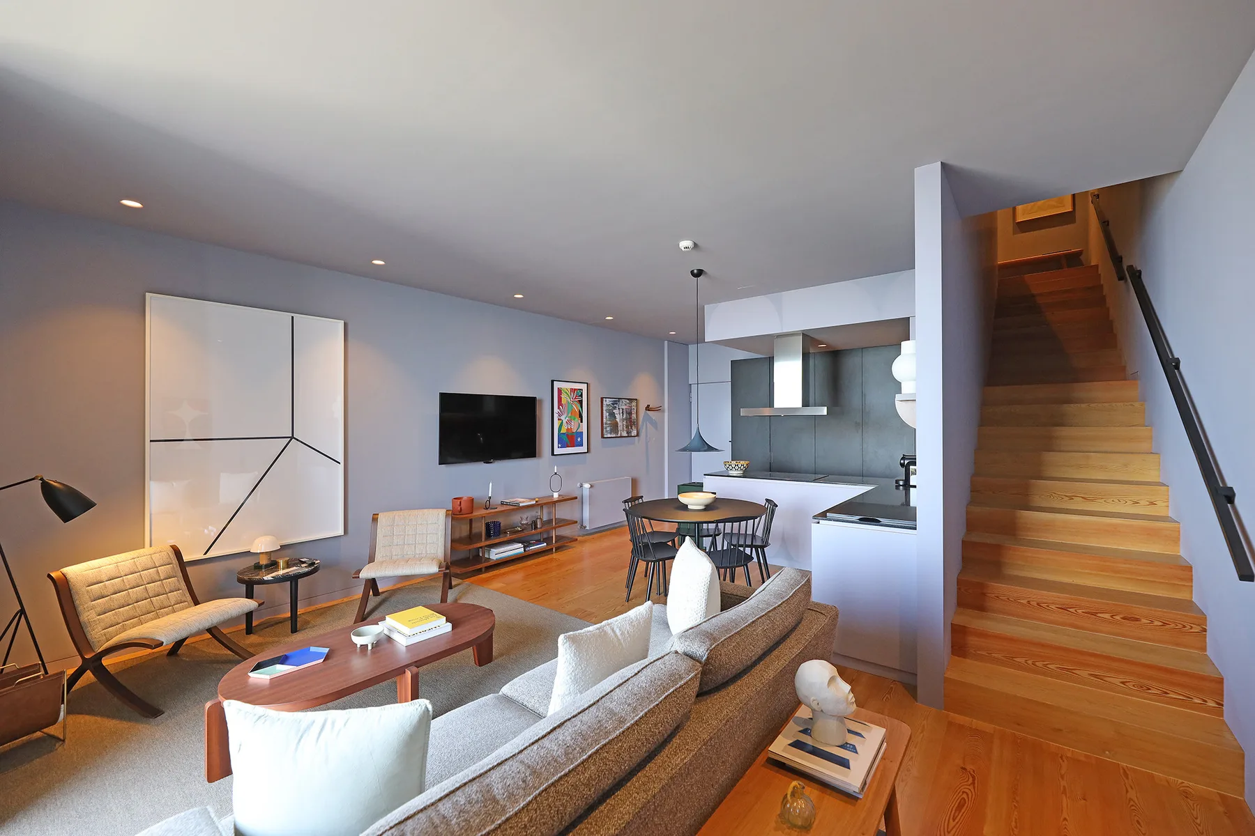 An open-plan living and dining area connects to a kitchen and staircase.