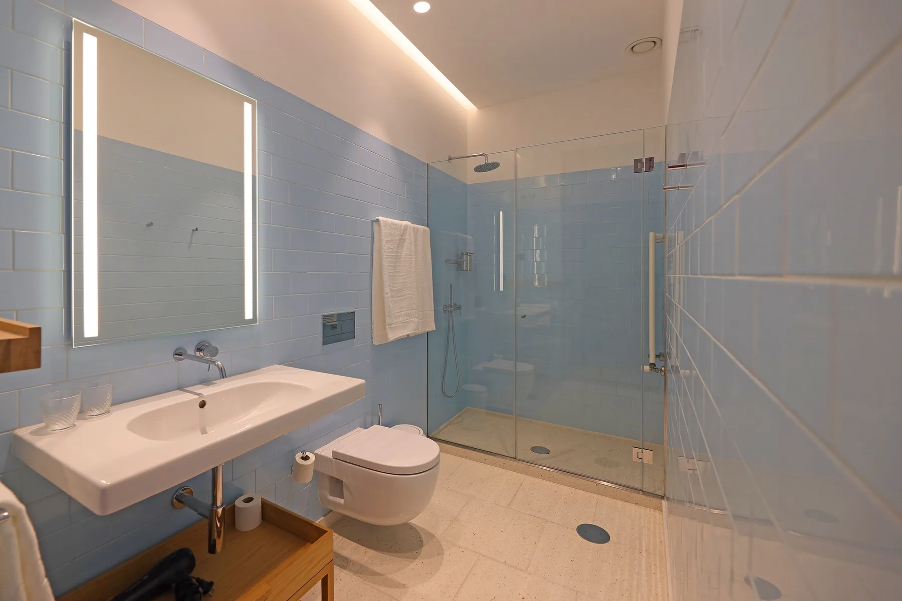 A tiled bathroom with a sink, toilet, and glass shower.
