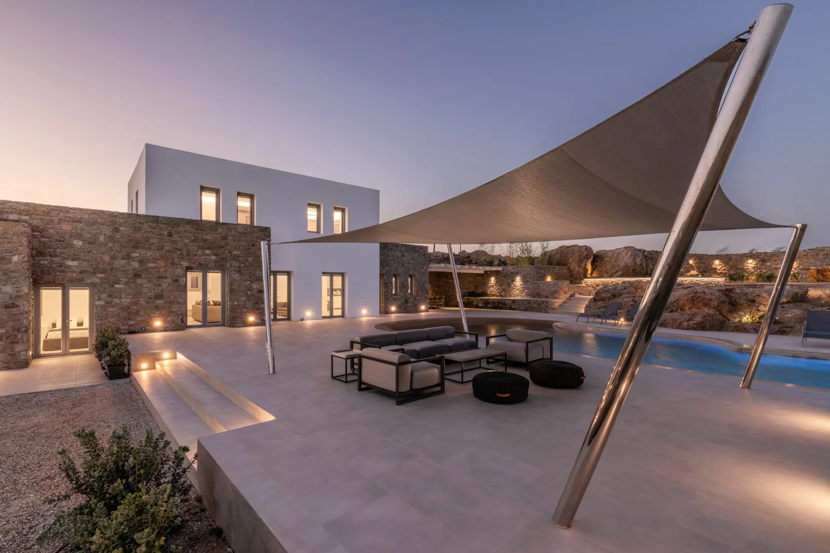 Modern villa patio with outdoor seating and a large shade canopy.