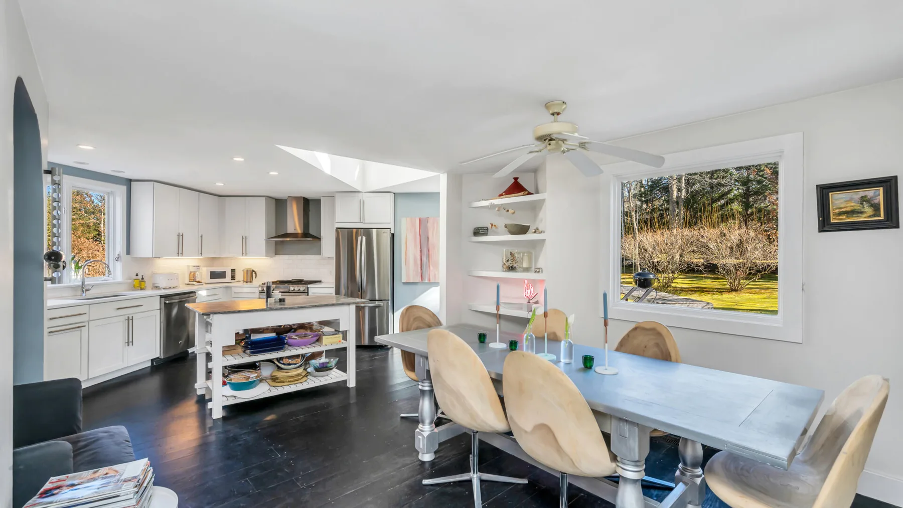 Una cocina y comedor luminosos con una isla central y ventanas grandes.