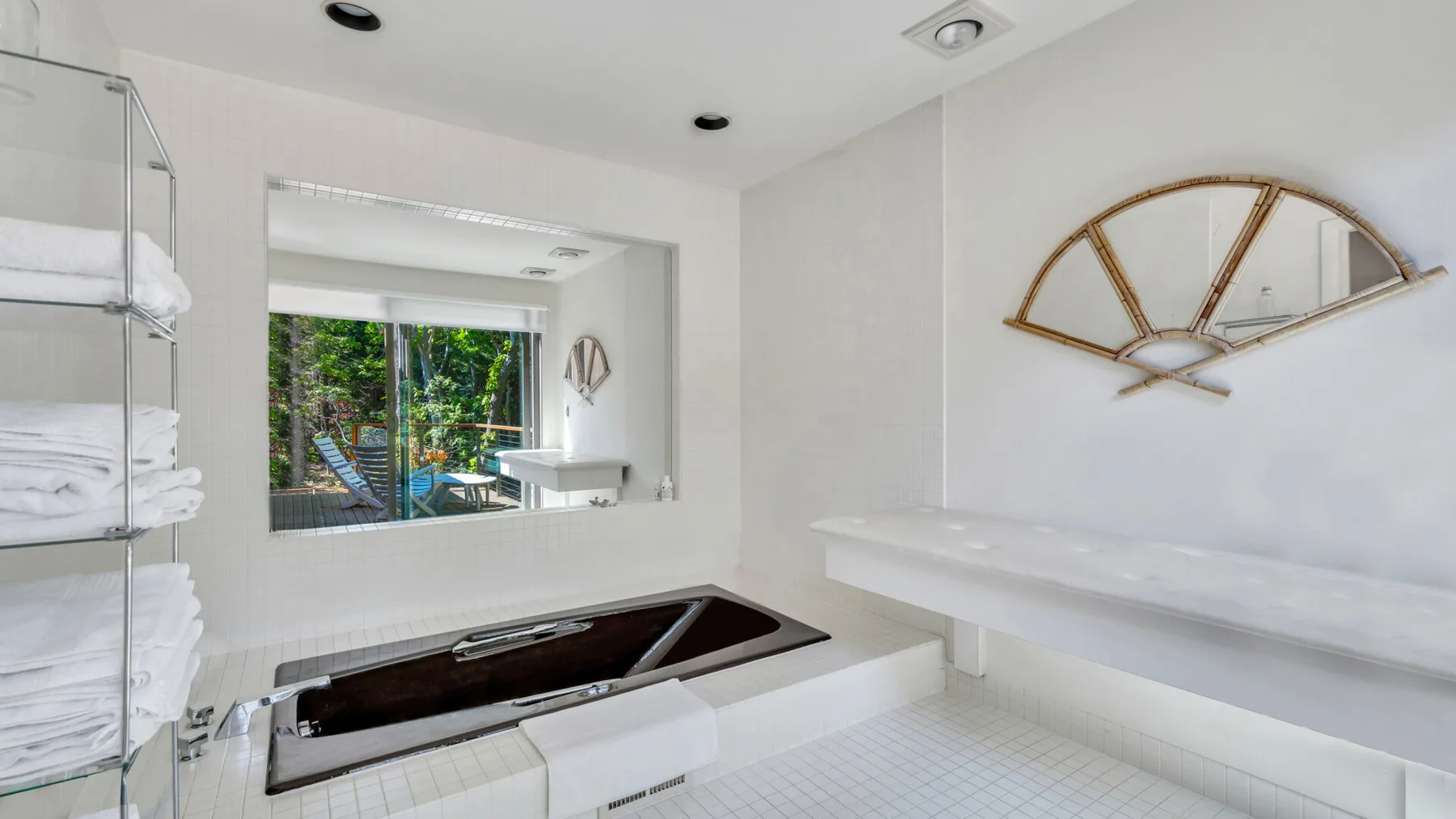 Un baño luminoso con una bañera empotrada y un espejo amplio en la pared.
