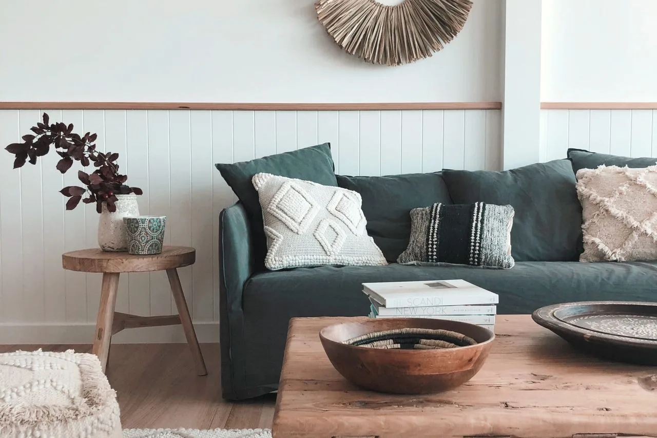 Living room with dark seating, patterned cushions, and a wooden coffee table.