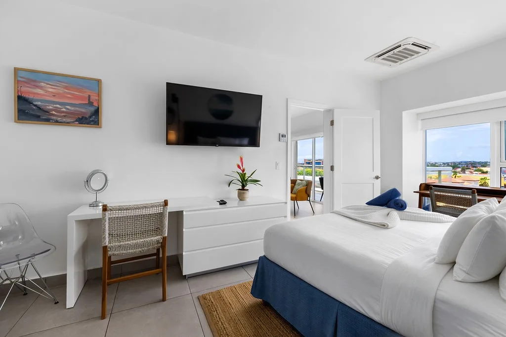 Your bedroom features crisp white linens and a wall-mounted TV for streaming your favorite shows before drifting off to sleep.