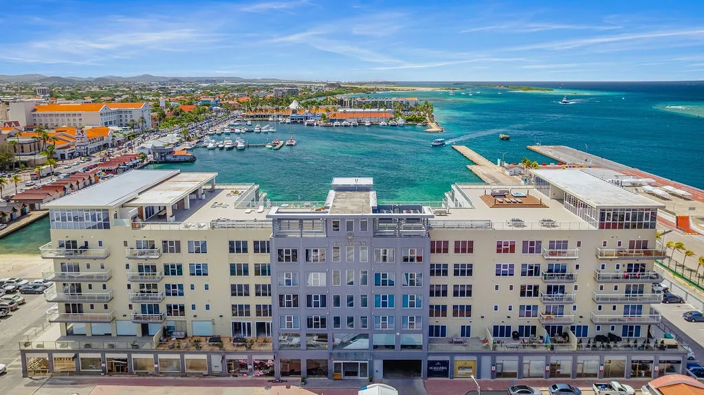 Waterfront property positioned along a marina with direct views of turquoise Caribbean waters, surrounded by coastal town architecture and island landscape.