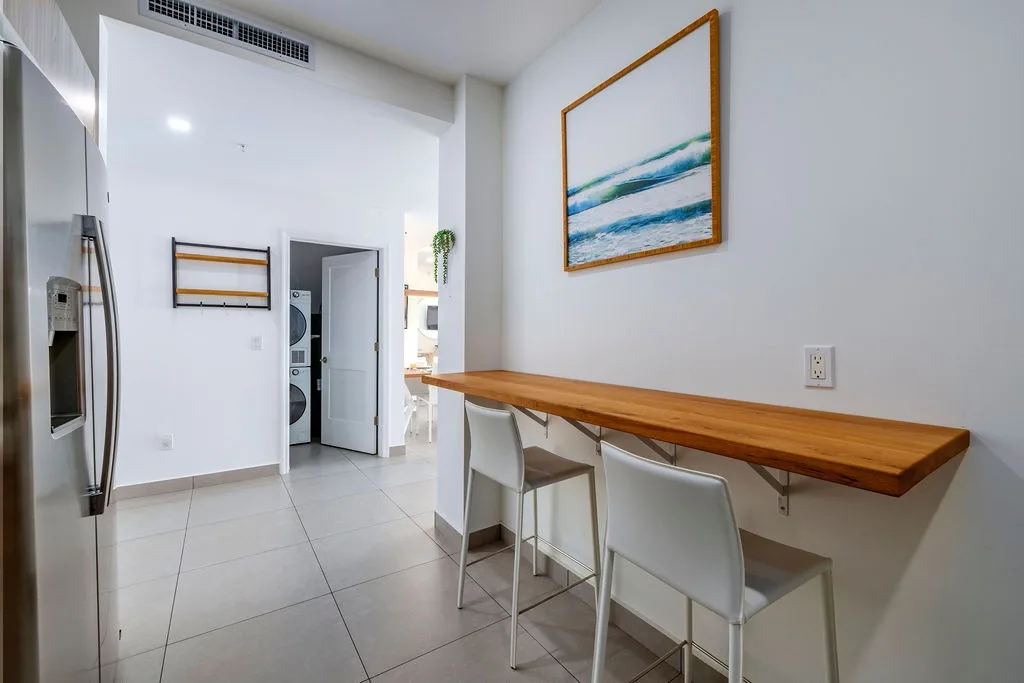 Enjoy morning coffee at your stylish breakfast bar, where coastal artwork and sleek design create the perfect start to your day.