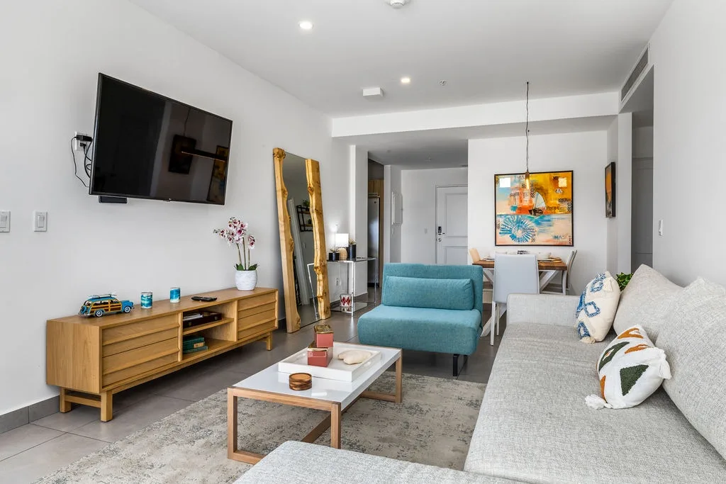 Settle into your bright living space with comfy seating, modern décor, and a cozy spot to relax. Sunshine filters in, while cheerful artwork adds warmth and personality throughout.
