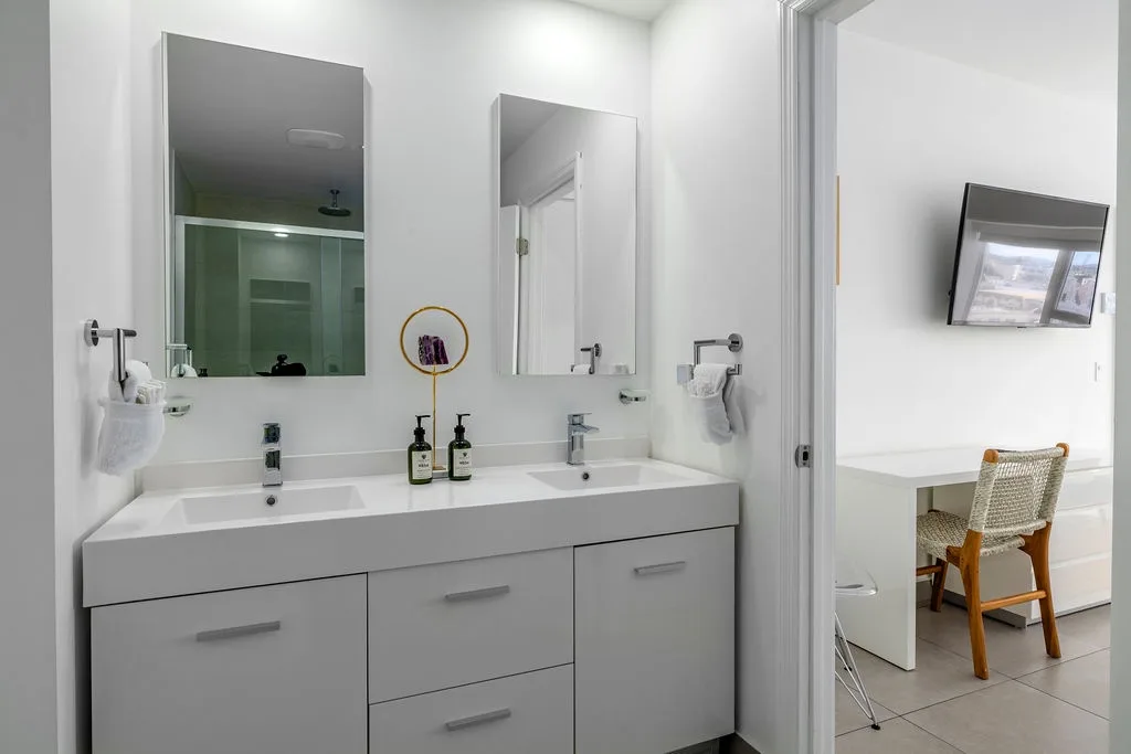 Step into a sleek, all-white modern bathroom designed with clean lines, a serene space to refresh and unwind.