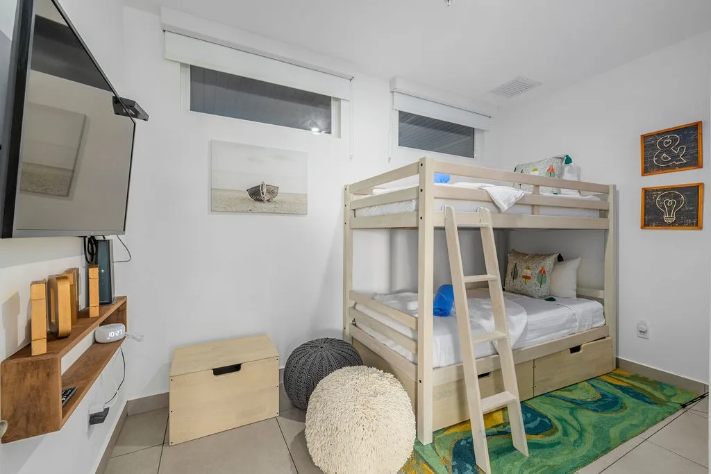 Maximize your space with comfort in this cozy room featuring a sturdy wooden bunk bed, perfect for families or groups traveling together.