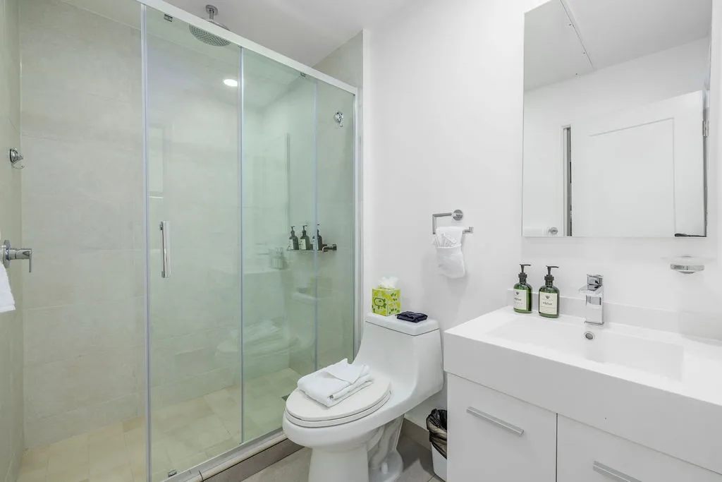 A bright, modern bathroom with a spacious walk-in shower, sleek vanity, and thoughtful touches like quality amenities awaits your morning refresh.