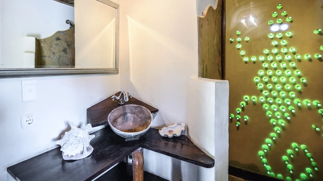 Cama y baño del bungalow Gecko