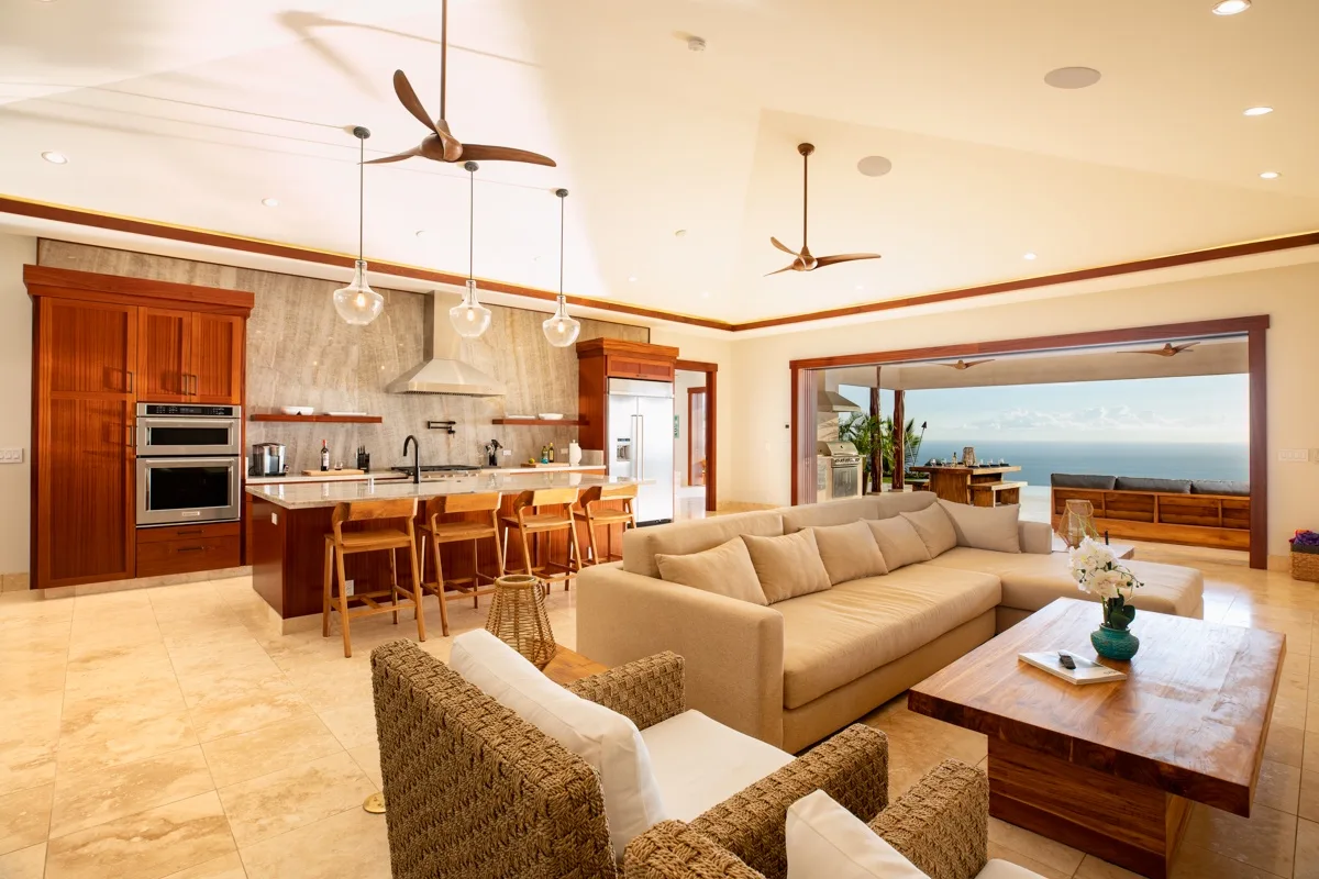 Una cocina y sala de estar de concepto abierto dan a un patio con vistas al agua.
