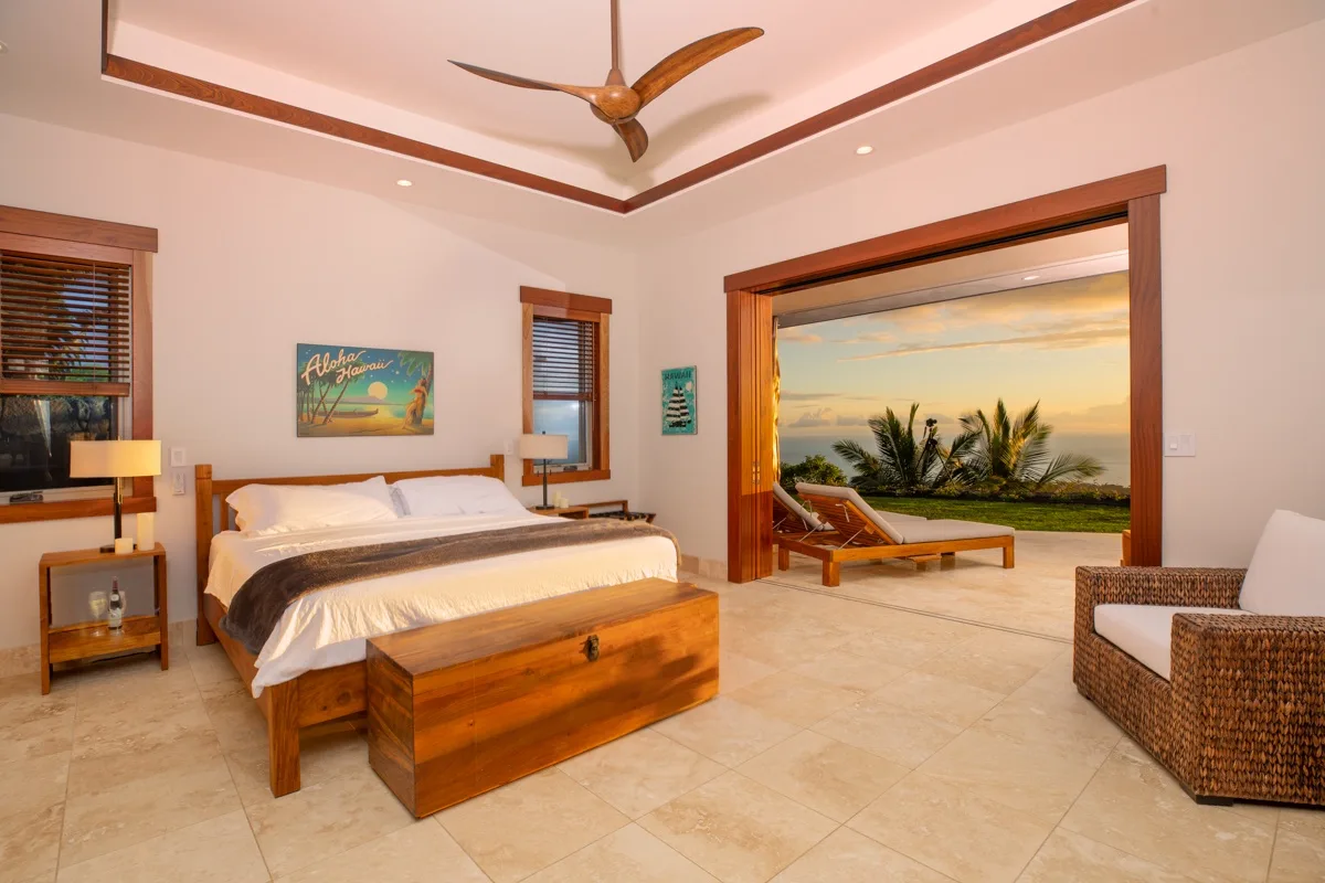 Un dormitorio con una cama de madera y una vista abierta hacia el mar.