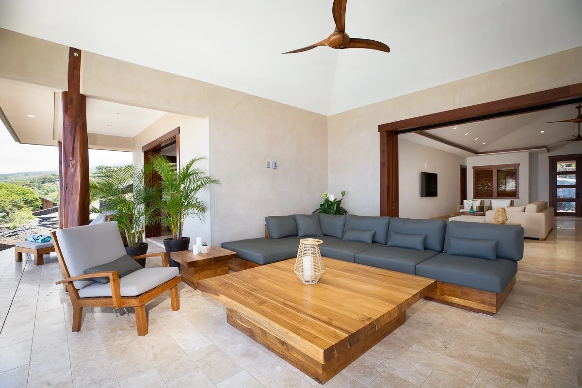 Una sala de estar amplia con un sofá seccional azul y una mesa de centro de madera.