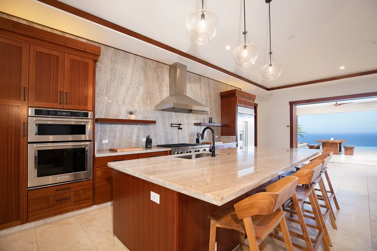 Una cocina amplia con una isla central y asientos de madera.