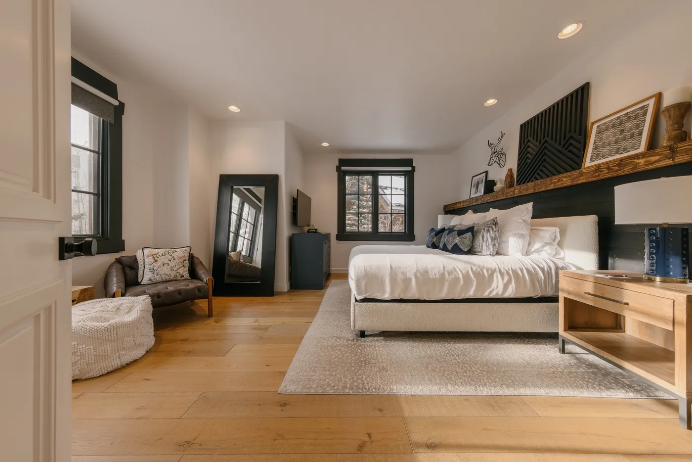 A bedroom with a bed, a window, and a sitting area.
