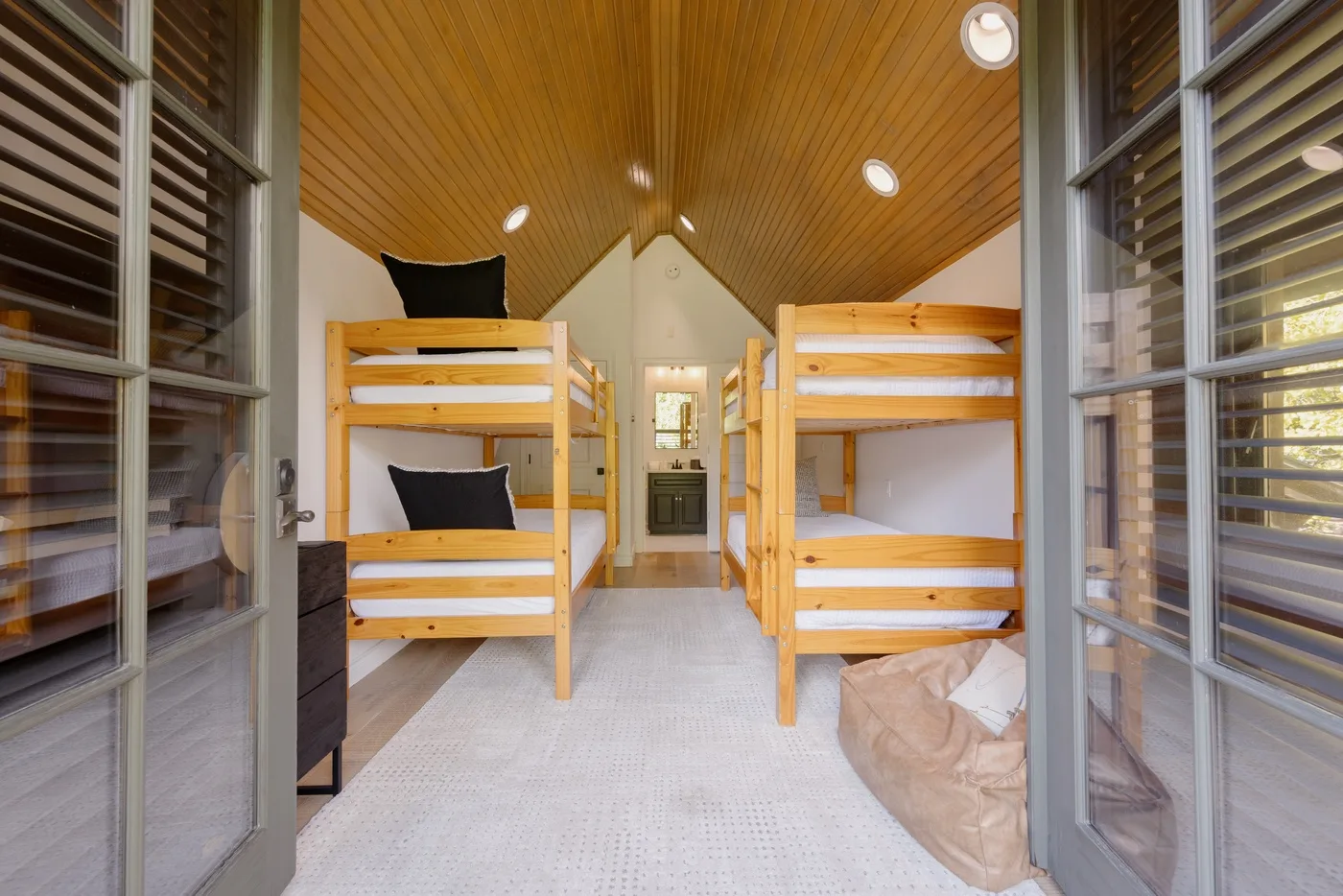 A bunk room with wooden bunk beds arranged along both sides.