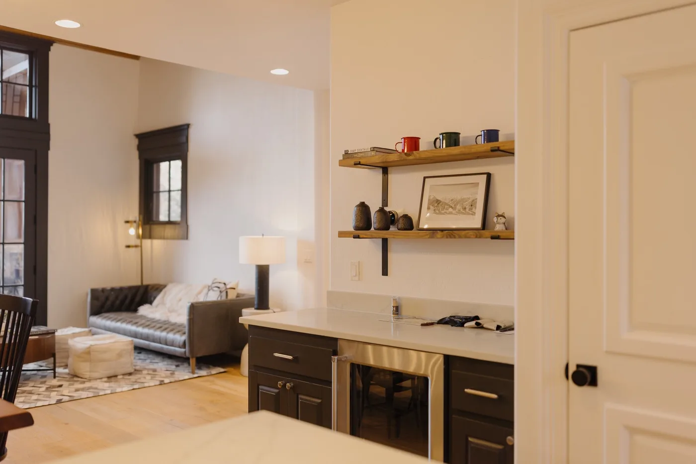 A bright room combines a compact kitchen counter with a small seating area.