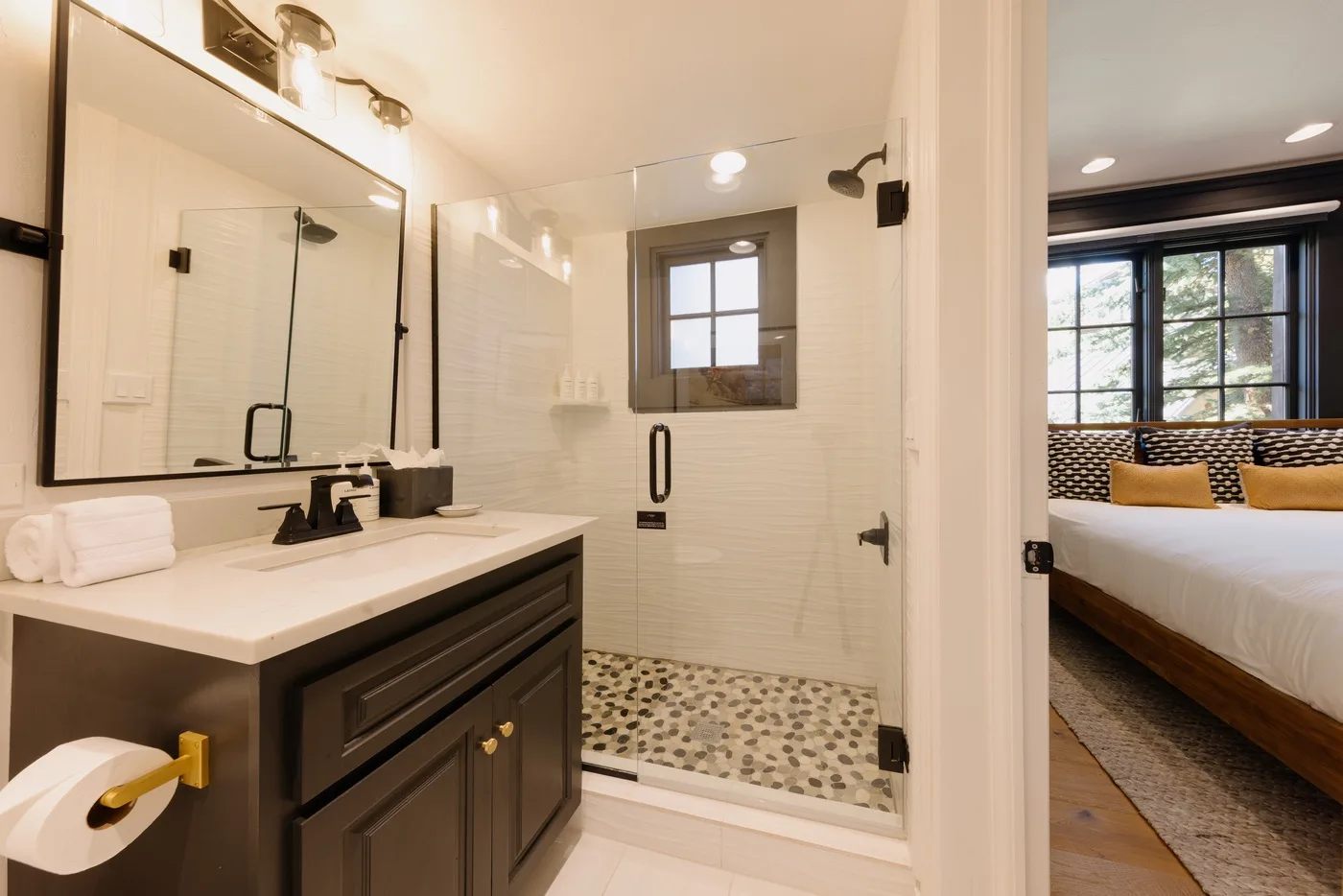 A bright bathroom with a wide vanity and a glass-enclosed shower.