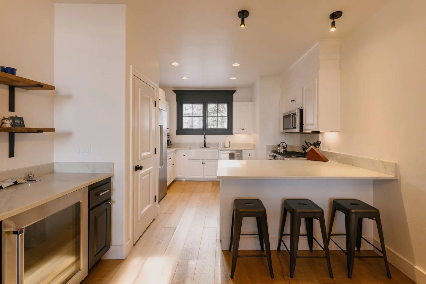 A bright kitchen with a central island and dark-framed window.