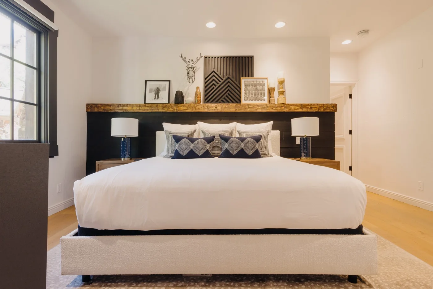 A bedroom with a large bed and decorative artwork above the headboard.