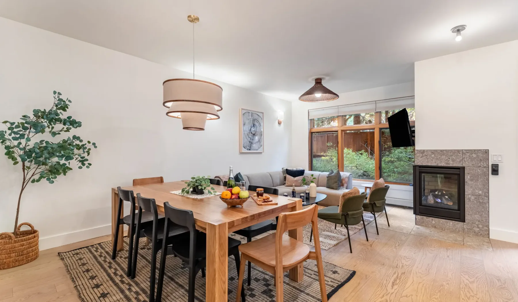 Un espacio abierto de comedor y sala de estar con mesa de madera y asientos.