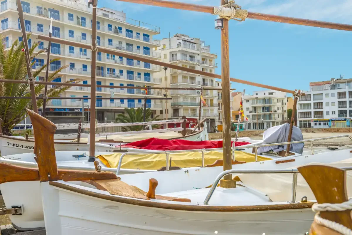 Hay barcos amarrados junto a un paseo marítimo con edificios de apartamentos.