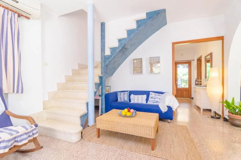 Una sala luminosa con asientos azules y una escalera.