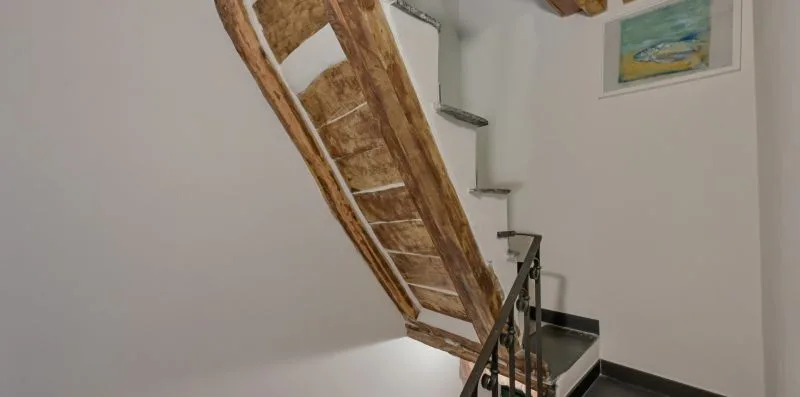 Una escalera interior de madera con un cuadro enmarcado en la pared.