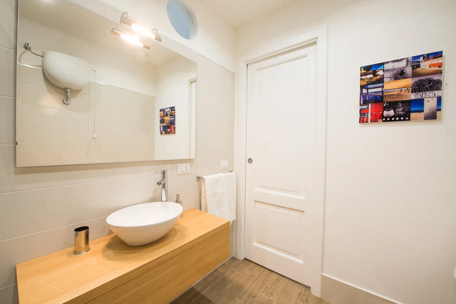 A bathroom vanity with a vessel sink, mirror, and closed door.