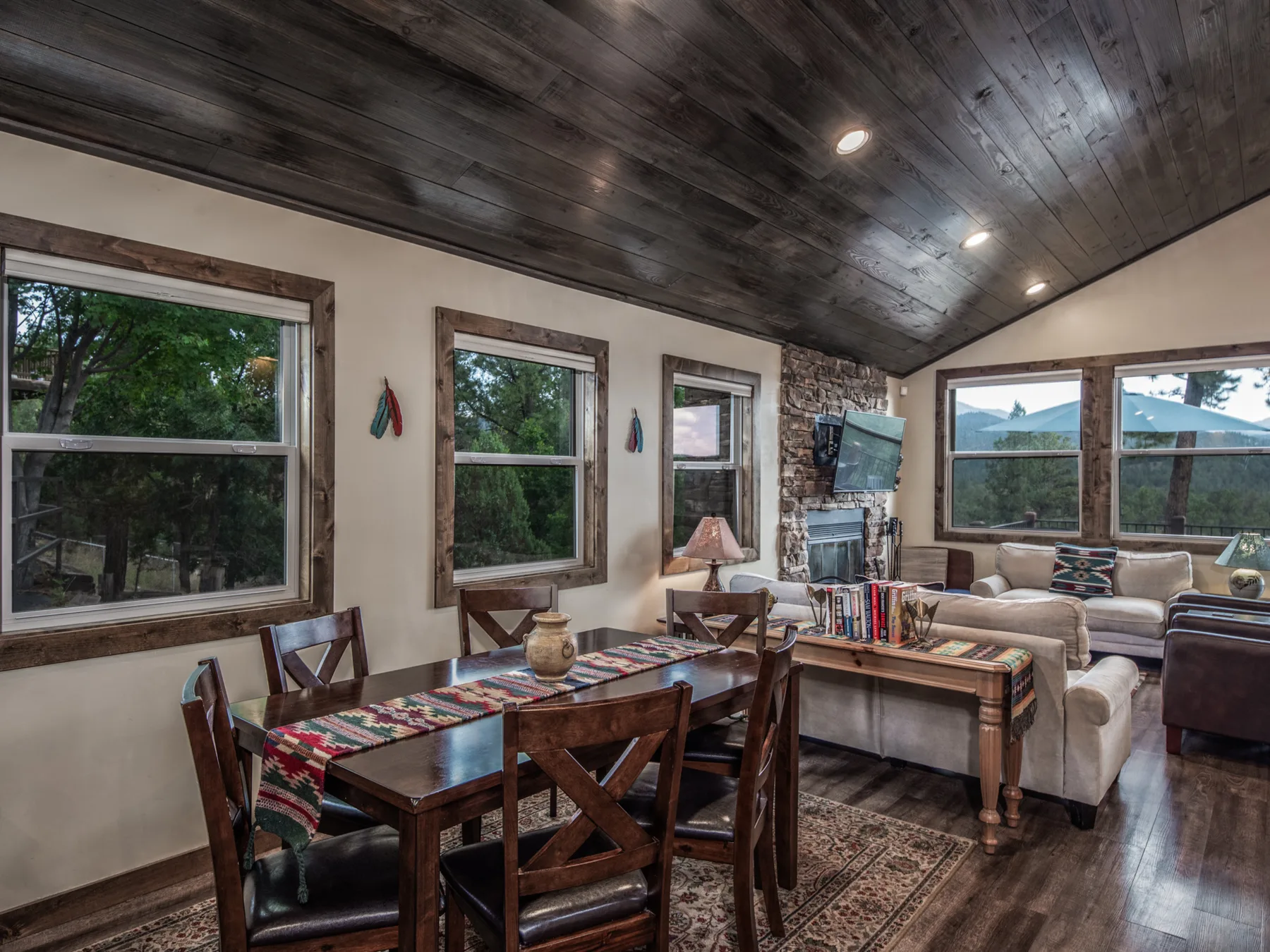 A living room with dining seating, a sofa, and large windows.