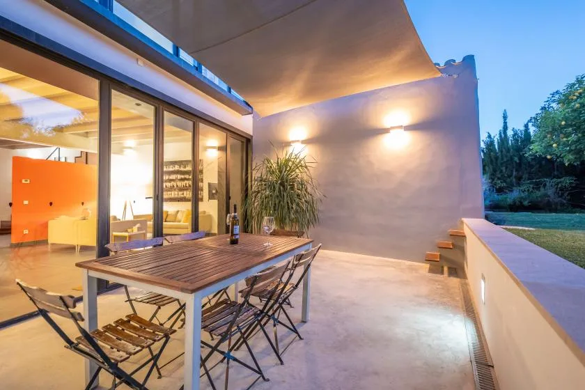 Una terraza comedor con una mesa junto a grandes puertas de vidrio.