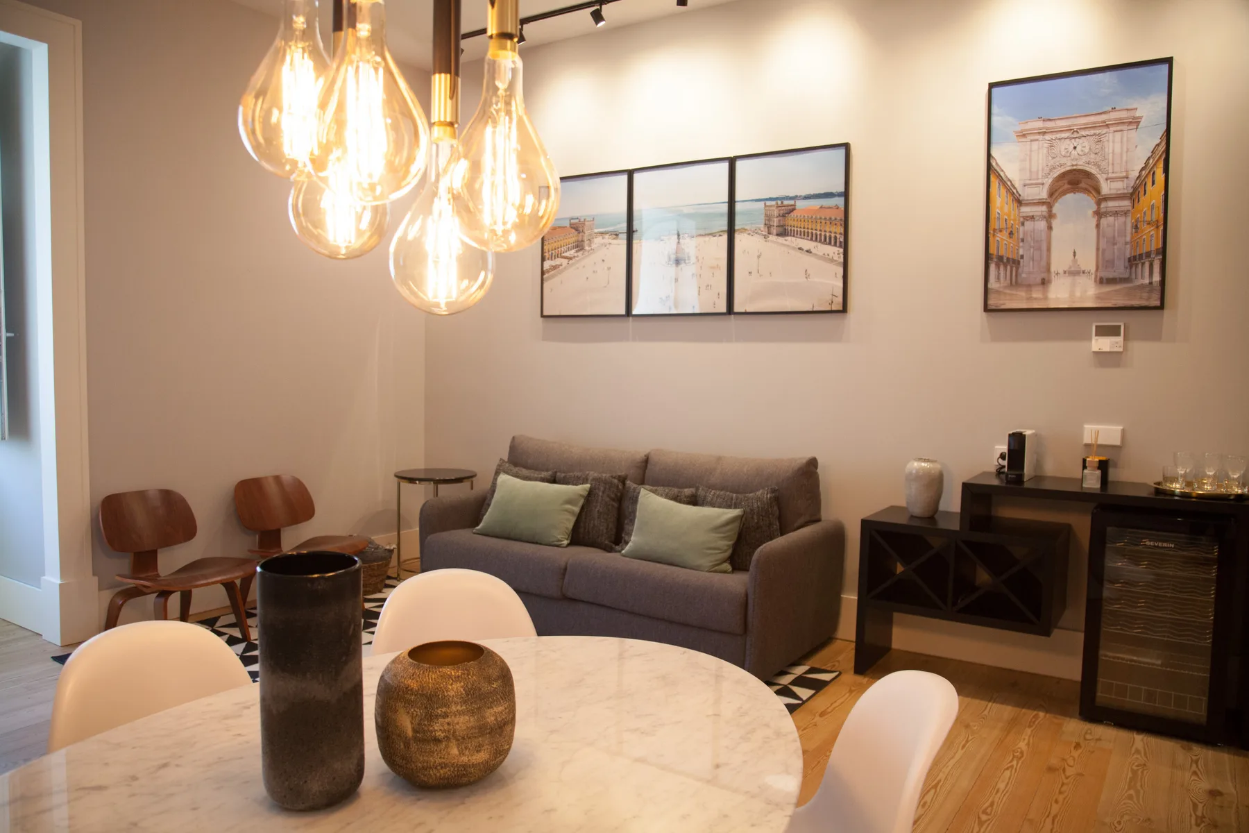 Living room with seating, pendant lights, and framed artwork on the walls.