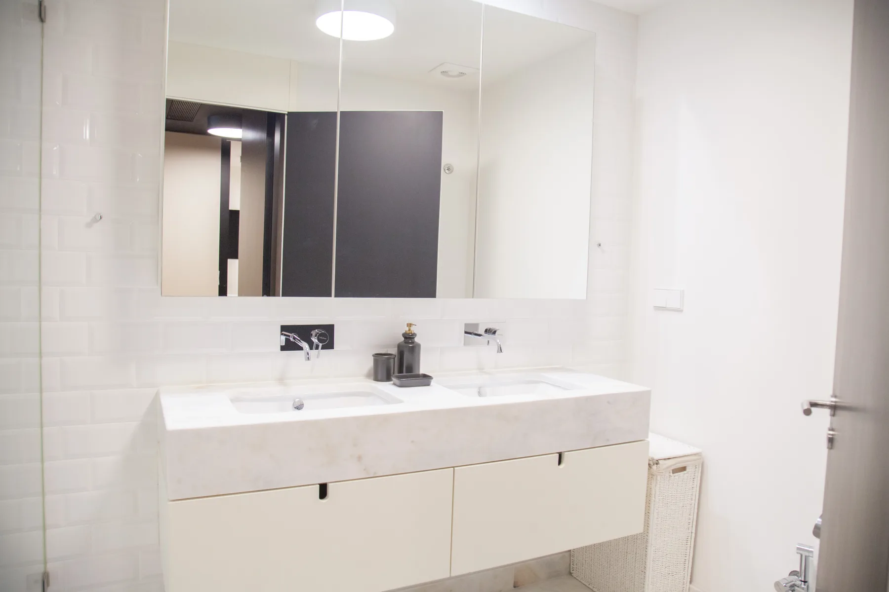 A bright bathroom with a wide sink beneath a large mirror.