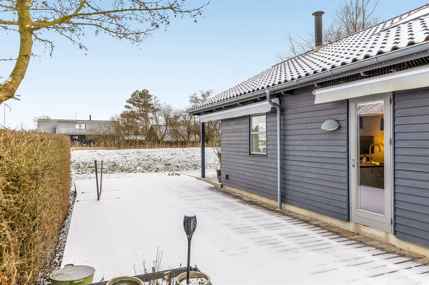 Un patio cubierto de nieve junto a una casa.