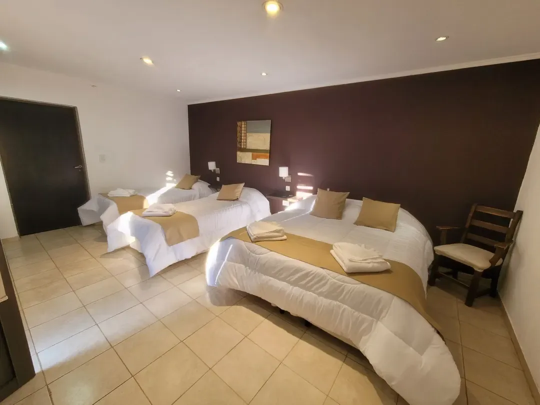 Habitación con una cama doble, dos camas individuales y una cuna.