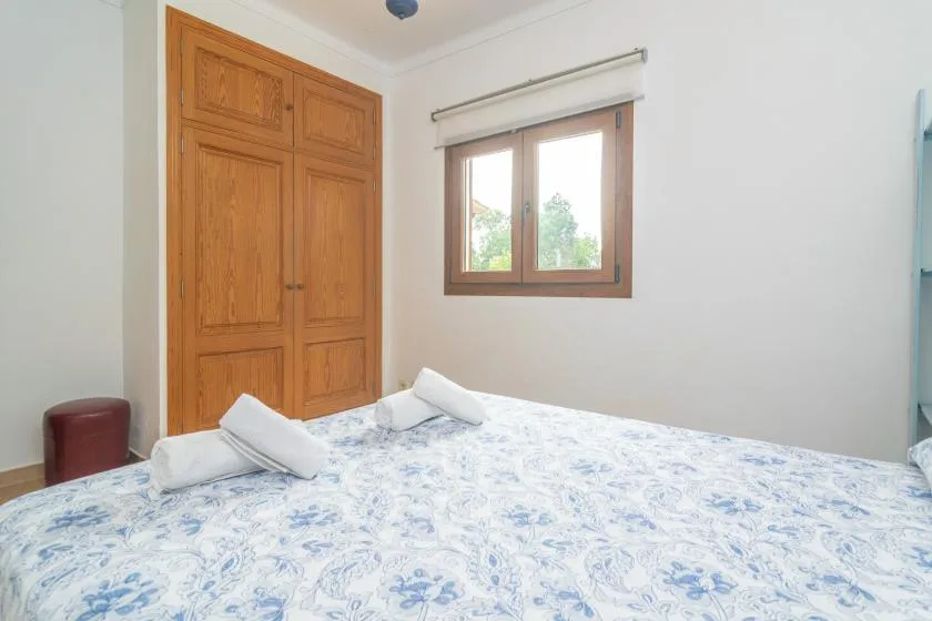 A bedroom with a bed covered in a blue-and-white patterned bedspread.