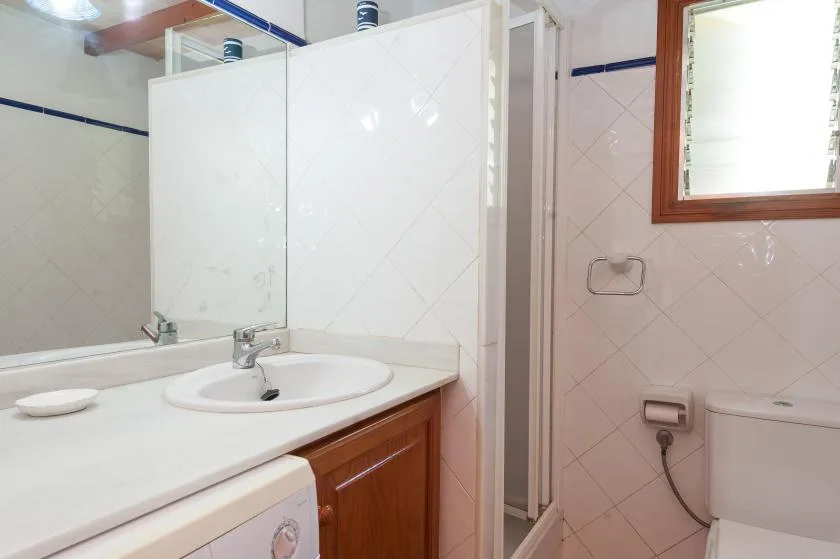 A tiled bathroom with a sink, mirror, and shower.