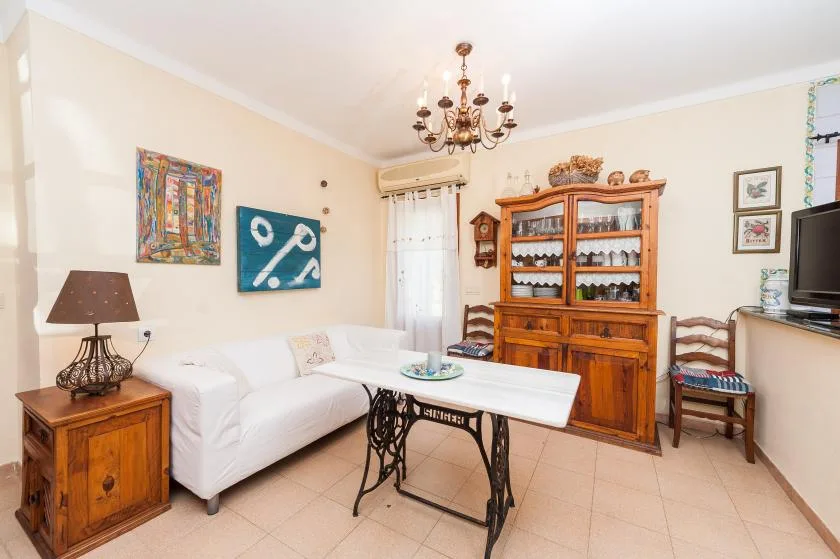 A living room with a white sofa and a wooden display cabinet.