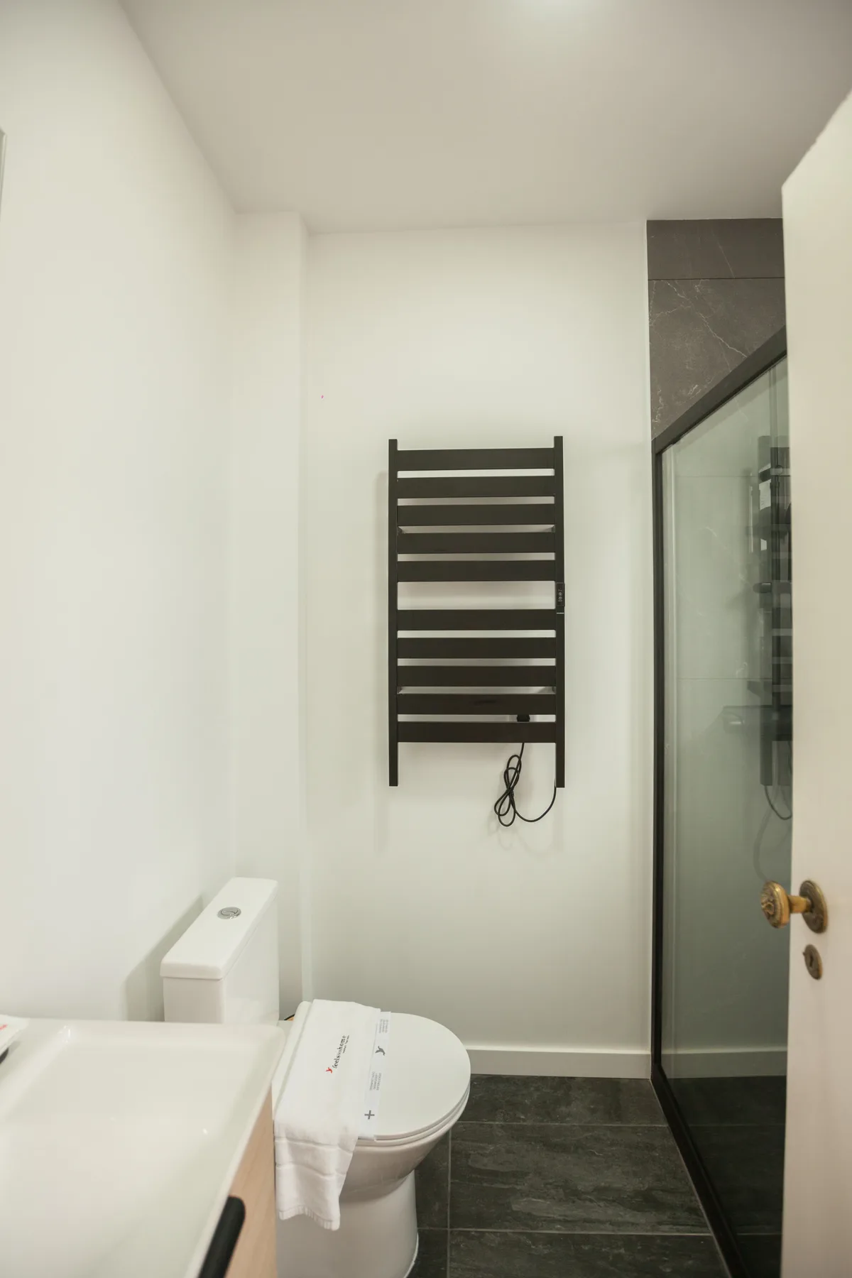 A bathroom with a sink, toilet, and glass shower.
