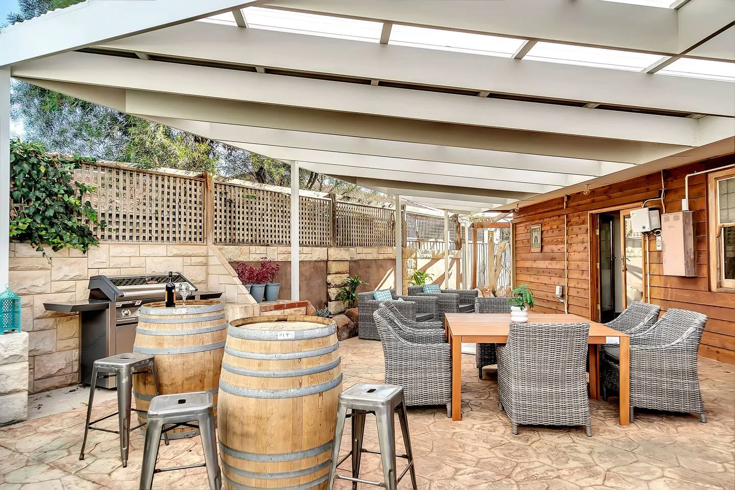 Reúnanse en el patio cubierto para comer al aire libre, donde los muebles de exterior y la barbacoa crean el ambiente para comidas informales y veladas relajadas.