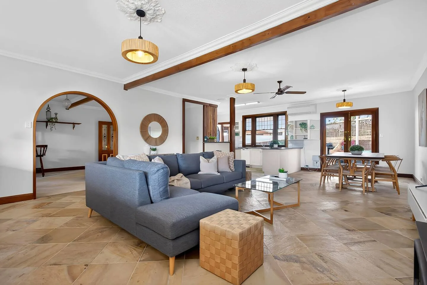 Una sala de estar con sofá seccional y mesa de centro se abre a un comedor.