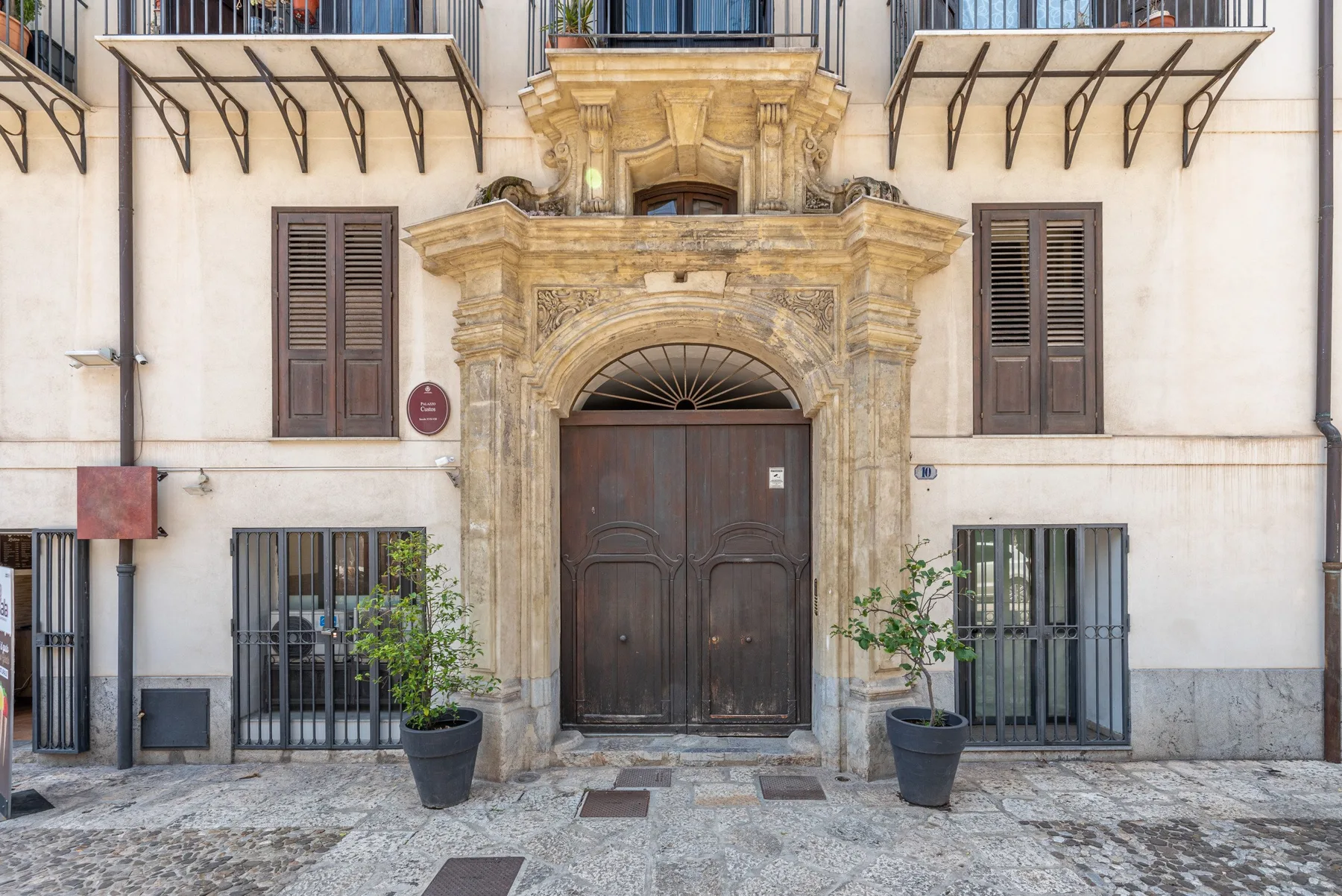A historic-looking building entrance with a large arched doorway and barred windows.