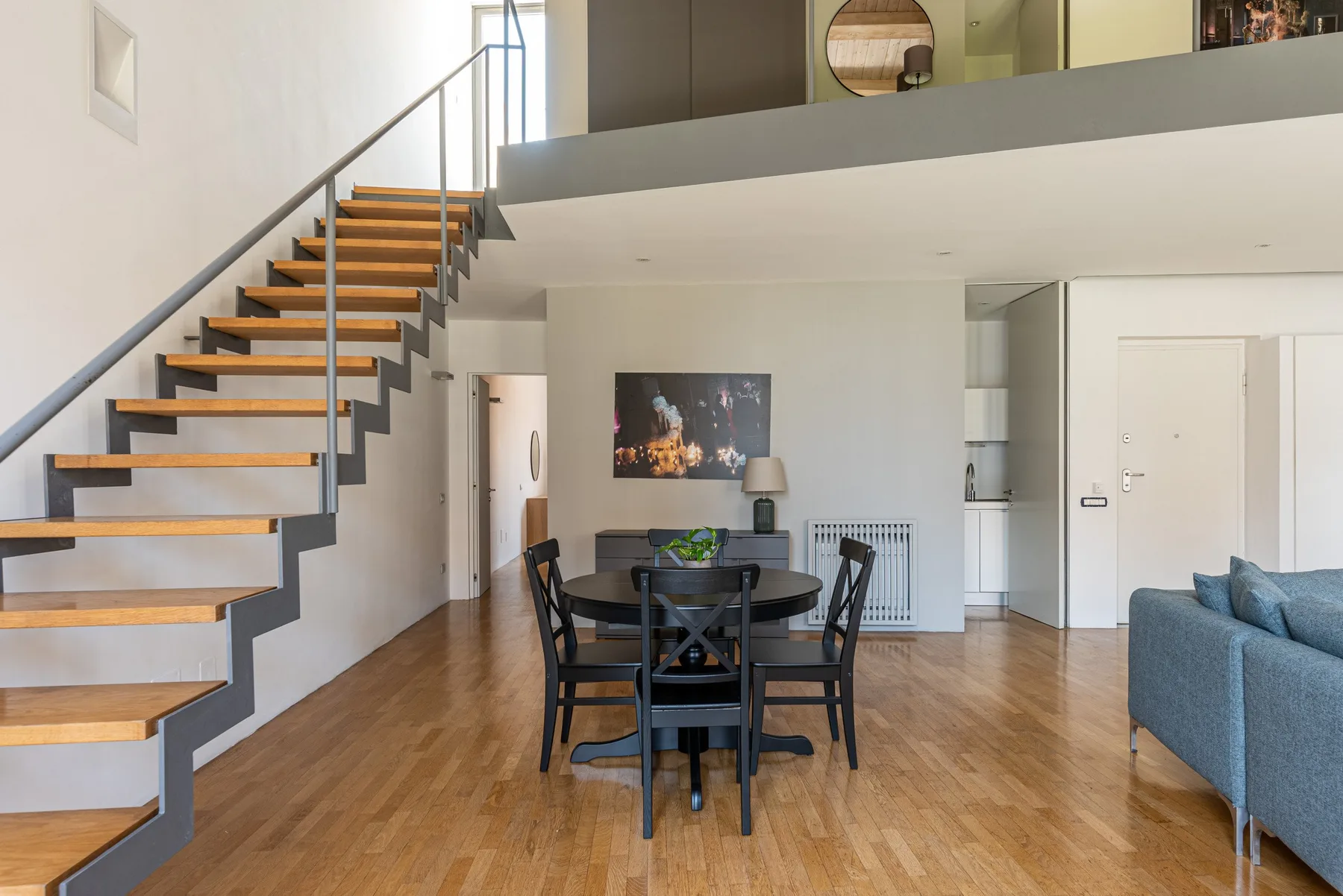 An open-plan living and dining area with a staircase and table.