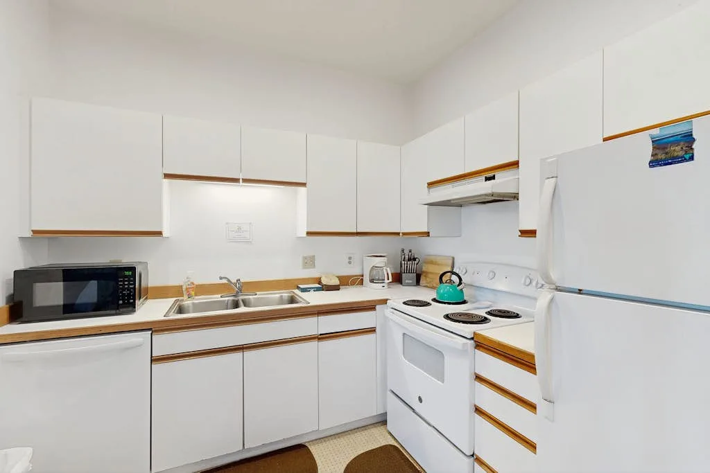 Una cocina luminosa con gabinetes blancos y una estufa.