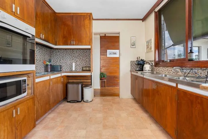 A kitchen with wooden cabinets, countertops, and a tiled backsplash.