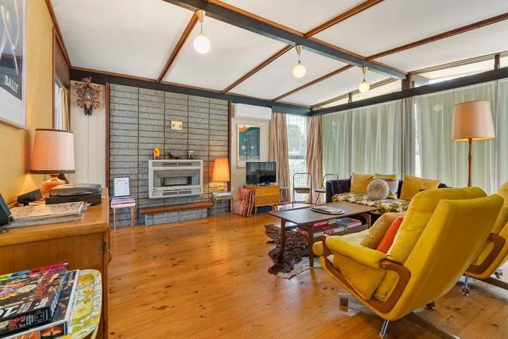 A living room with yellow seating arranged around a low coffee table.