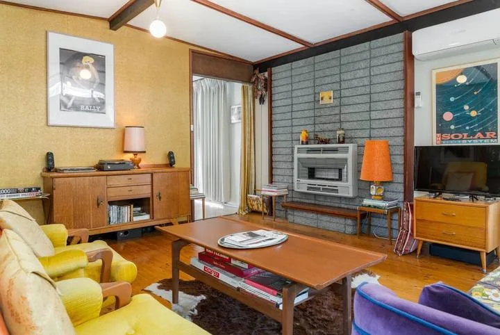 A living room with seating, a coffee table, and a television.