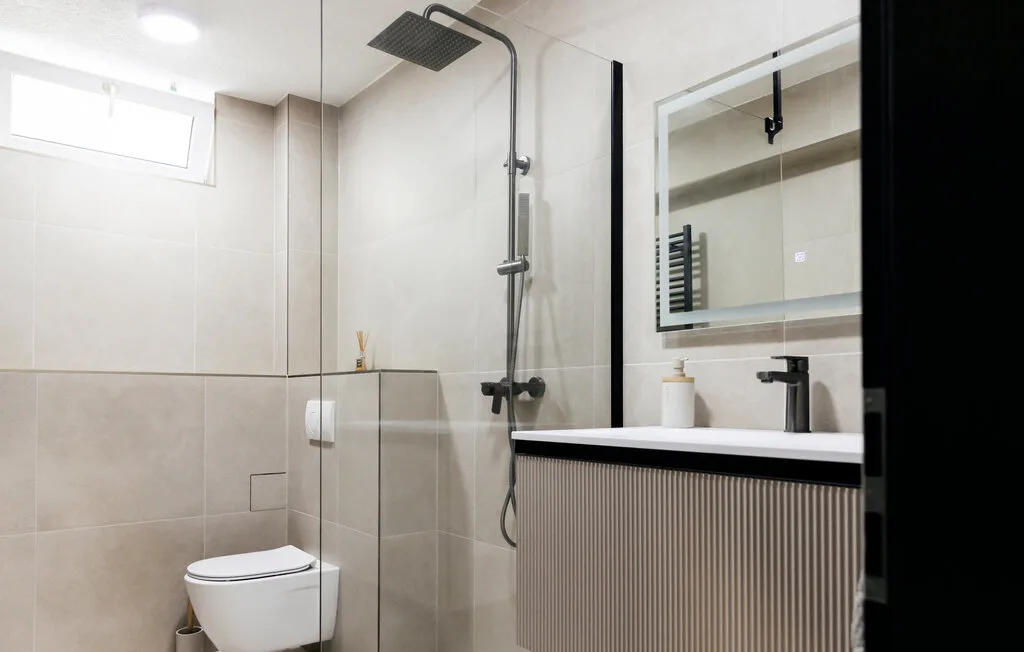 Un baño moderno con ducha, inodoro y lavabo.